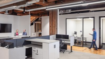 Office space with exposed wood and cieling ductwork and modern cubicles