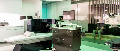 A LASIK treatment room with a Femto LDV Z8 laser system and microscope, illuminated in green light.